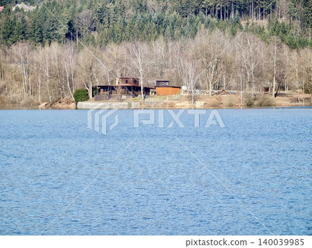 Peaceful rural retreat showcasing luminous water alongside natural forest and wooden structures 140039985