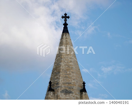 Weathered church spire with crosses. Historical religious structure with finials touching clear blue sky Weathered church spire with crosses. Historical religious structure with finials touching clear blue sky 140040191