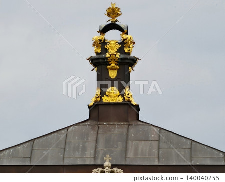 Detailed view of ornate gilded metalwork on municipal roof highlighting civic pride and historic significance Detailed view of ornate gilded metalwork on municipal roof highlighting civic pride and historic significance 140040255