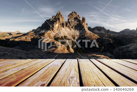Wooden deck foreground The sunlight covers the rocks. Tre Cime di Lavaredo mountains, majestic view of the popular place, nature background Wooden deck foreground The sunlight covers the rocks. Tre Cime di Lavaredo mountains, majestic view of the popular place, nature background 140040269