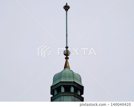 Decorative copper structure with patina. Detailed view of copper finial on turret against gray sky Decorative copper structure with patina. Detailed view of copper finial on turret against gray sky 140040420