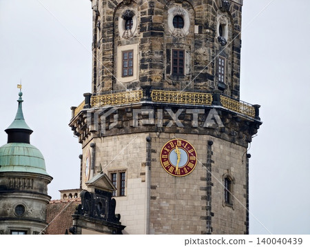 Old stone clock tower under cloudy sky. Weathered masonry tower with decorative cornices and clock face 140040439