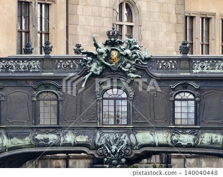 Elaborate bronze sculpture featuring cherubs and masks over stone architecture with ornate detailing 140040448
