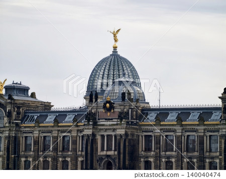 Historic museum rooftop. Cultural landmark featuring golden sculpture and detailed masonry structure Historic museum rooftop. Cultural landmark featuring golden sculpture and detailed masonry structure 140040474