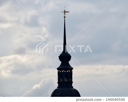 Sleek spire against cloudy backdrop. Refined and pointed tower amid moody sky with artistic framing Sleek spire against cloudy backdrop. Refined and pointed tower amid moody sky with artistic framing 140040500