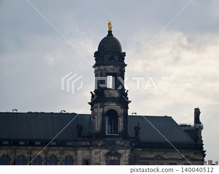 Silhouette of tower and buildings against stormy sky highlighting composition and atmospheric depth Silhouette of tower and buildings against stormy sky highlighting composition and atmospheric depth 140040512