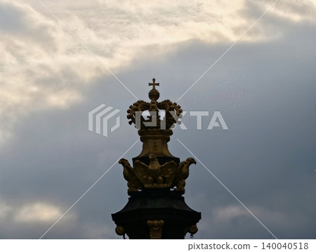 Intricate crown sculpture emphasizing baroque artistry with gilded details and atmospheric cloud patterns Intricate crown sculpture emphasizing baroque artistry with gilded details and atmospheric cloud patterns 140040518