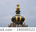 Ornate golden crown with figures. Richly decorated crown with gold accents and historic background 140040522