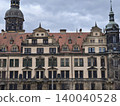Ornate baroque facade with towers and spires, detailed ornament, weathered stone and historic charm 140040528