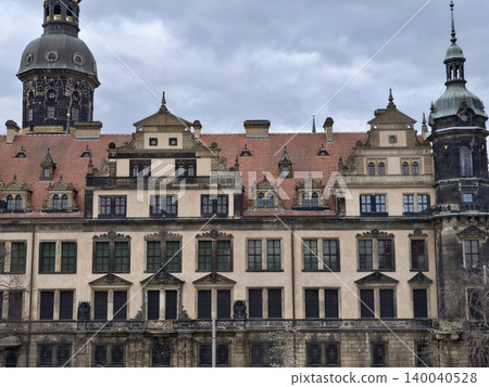 Ornate baroque facade with towers and spires, detailed ornament, weathered stone and historic charm Ornate baroque facade with towers and spires, detailed ornament, weathered stone and historic charm 140040528