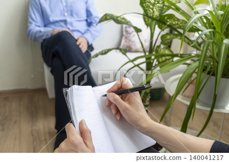 Close Up of Psychologist Hand Taking Notes During Therapy Session with Client Close Up of Psychologist Hand Taking Notes During Therapy Session with Client 140041217