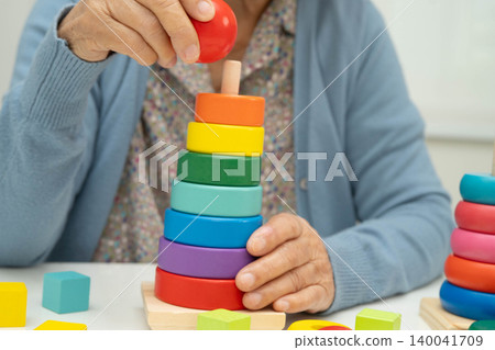 Asian elderly woman playing enhancing skill board game. Asian elderly woman playing enhancing skill board game. 140041709