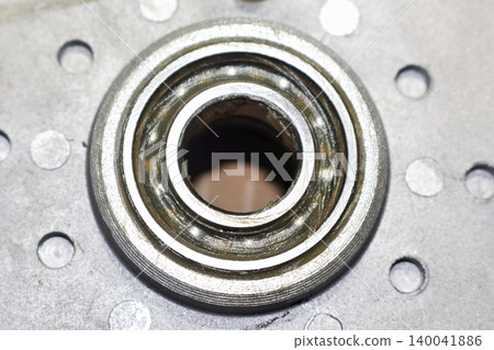 Close-up of an electric bicycle motor ball bearing with fresh lubricant applied after removing the protective seal during maintenance and repair procedure Close-up of an electric bicycle motor ball bearing with fresh lubricant applied after removing the protective seal during maintenance and repair procedure 140041886