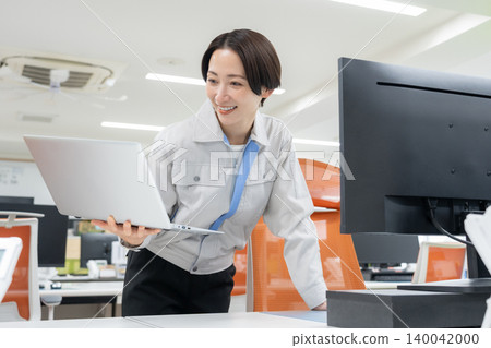 辦公室裡，一位身著工作服的中年女工程師 140042000