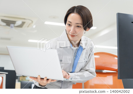 辦公室裡，一位身著工作服的中年女工程師 140042002