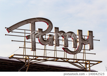 Weathered Soviet-era neon sign Rhythm club stands against a pale sky, showing vintage design and decay in Russia Weathered Soviet-era neon sign Rhythm club stands against a pale sky, showing vintage design and decay in Russia 140042523