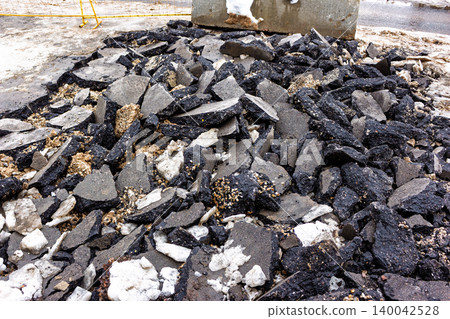 Pile of broken asphalt chunks and debris from road repair work, suitable for construction or demolition themes Pile of broken asphalt chunks and debris from road repair work, suitable for construction or demolition themes 140042528