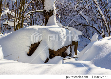 Abandoned cellar entrance hidden under deep, pristine snowdrifts in a winter forest, hinting at forgotten secrets and potential danger Abandoned cellar entrance hidden under deep, pristine snowdrifts in a winter forest, hinting at forgotten secrets and potential danger 140042538