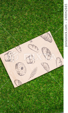 brown paper bag on Green Bush Trees Foliage Background. Eco Nature Friendly Style,Go to zero waste ecological shopping bag on the green grass. An alternative to disposable packages. Zero waste concept brown paper bag on Green Bush Trees Foliage Background. Eco Nature Friendly Style,Go to zero waste ecological shopping bag on the green grass. An alternative to disposable packages. Zero waste concept 140042685