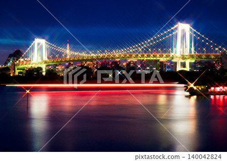A beautiful night view photograph taken from Shiokaze Park, capturing the sparkling Rainbow Bridge and the red light trails of houseboats using a cross filter. A beautiful night view photograph taken from Shiokaze Park, capturing the sparkling Rainbow Bridge and the red light trails of houseboats using a cross filter. 140042824