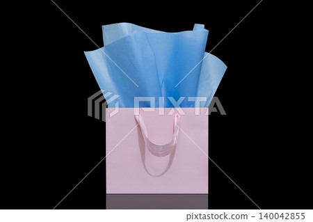 Craft paper gift bag with tissue paper isolated on a black background 140042855