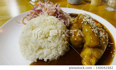 Traditional vietnamese dish arranged on plate at restaurant table. Steamed rice paired with tender chicken and portion of cabbage, creating balanced and inviting composition with clean presentation Traditional vietnamese dish arranged on plate at restaurant table. Steamed rice paired with tender chicken and portion of cabbage, creating balanced and inviting composition with clean presentation 140042882