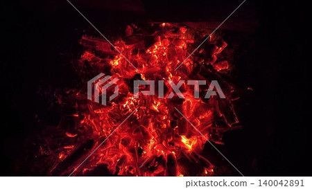 Close up of glowing charcoal embers burning with red and orange tones at night. Soft heat and shimmering texture create magical atmosphere. Warm abstract scene symbolizing warmth and quiet at nature Close up of glowing charcoal embers burning with red and orange tones at night. Soft heat and shimmering texture create magical atmosphere. Warm abstract scene symbolizing warmth and quiet at nature 140042891