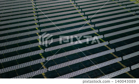 Aerial view of large solar farm with long parallel rows of photovoltaic panels producing renewable electricity Aerial view of large solar farm with long parallel rows of photovoltaic panels producing renewable electricity 140043089