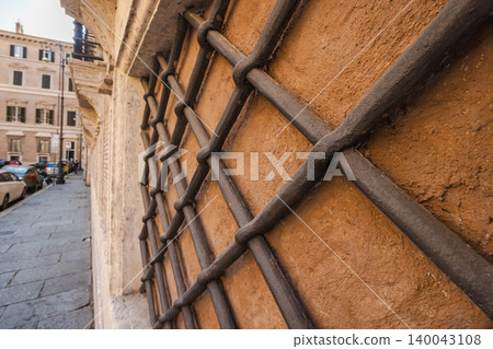 Close view of vintage iron window grille on historic building wall in Rome street Close view of vintage iron window grille on historic building wall in Rome street 140043108