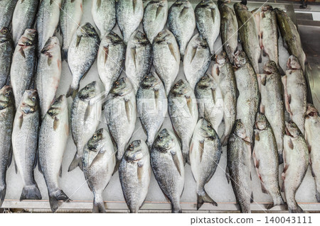 Fresh dorado sea bream and trout fish assortment displayed on ice at seafood market 140043111