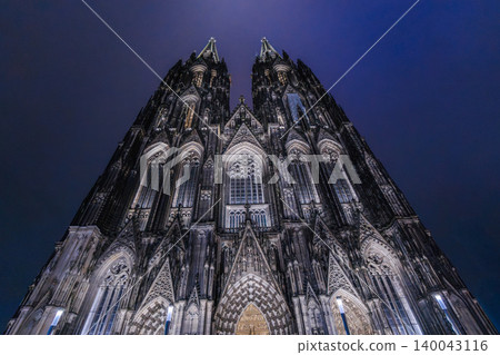 Illuminated Cologne Cathedral facade at night with dramatic gothic towers Illuminated Cologne Cathedral facade at night with dramatic gothic towers 140043116
