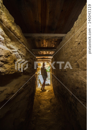 Young woman standing in narrow cave passage inside Aladzha Monastery Bulgaria Young woman standing in narrow cave passage inside Aladzha Monastery Bulgaria 140043119
