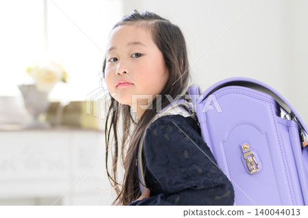 A Japanese girl turns around with her schoolbag on her back. A Japanese girl turns around with her schoolbag on her back. 140044013