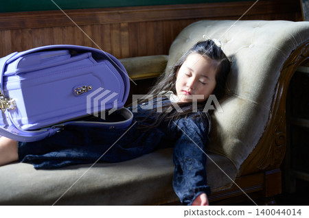 A Japanese girl with a school bag taking a nap on the sofa A Japanese girl with a school bag taking a nap on the sofa 140044014