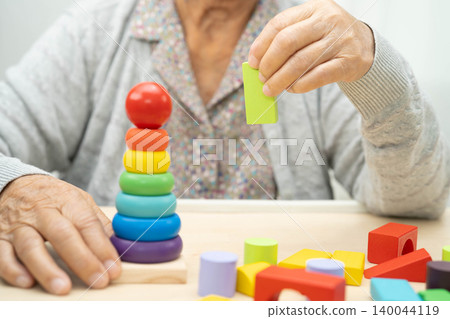 Asian elderly woman playing enhancing skill board game. Asian elderly woman playing enhancing skill board game. 140044119