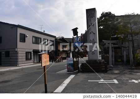 A stone monument at Sakurayama Hachimangu Shrine and the surrounding townscape in Takayama City, Gifu Prefecture, Japan, during the morning hours of the Spring Takayama Festival. A stone monument at Sakurayama Hachimangu Shrine and the surrounding townscape in Takayama City, Gifu Prefecture, Japan, during the morning hours of the Spring Takayama Festival. 140044419