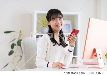 在辦公室使用智慧型手機的年輕女性 140044639