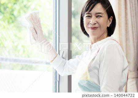 A woman cleaning windows A woman cleaning windows 140044722