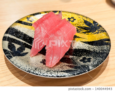 Nigiri sushi made with bluefin tuna on a conveyor belt sushi plate. Sushi rice topped with fresh bluefin tuna sashimi. Nigiri sushi made with bluefin tuna on a conveyor belt sushi plate. Sushi rice topped with fresh bluefin tuna sashimi. 140044943