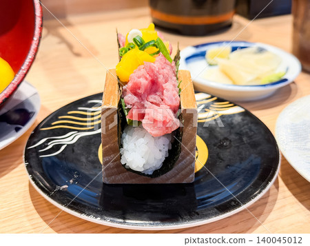 Toro-taku hand roll. A hand roll sushi with minced tuna and pickled radish on top of vinegared rice. Toro-taku hand roll. A hand roll sushi with minced tuna and pickled radish on top of vinegared rice. 140045012