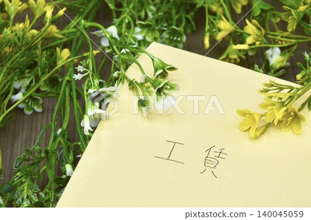 一個棕色信封，上面寫著“勞動工資”，還有乾燥花 140045059