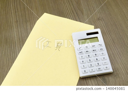 A brown envelope labeled "Wages" and a calculator 140045081