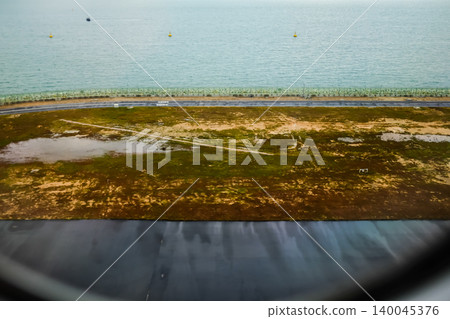 Looking from the airplane window of the landing scene. The scene of the airport apron. Travel and transportation concept. 140045376