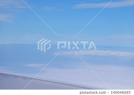 Looking through airplane window with dramatic cloudscape. white clouds with the blue sky from the high angle view. Cloudscape background. Nature scene. Looking through airplane window with dramatic cloudscape. white clouds with the blue sky from the high angle view. Cloudscape background. Nature scene. 140046085