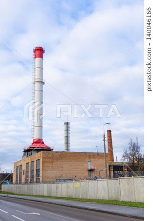 Factories with smokestacks and fences. View of factory with multiple chimneys and city surroundings Factories with smokestacks and fences. View of factory with multiple chimneys and city surroundings 140046166