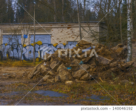 Debris cleanup ongoing. Site with scattered wreckage. Disorderly pile of rubble near graffiti wall Debris cleanup ongoing. Site with scattered wreckage. Disorderly pile of rubble near graffiti wall 140046192