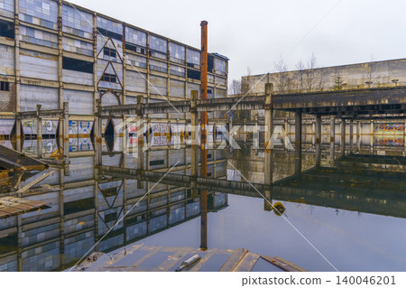 Industrial decay reflected. Aged industrial space with water reflections and weathered structures Industrial decay reflected. Aged industrial space with water reflections and weathered structures 140046201