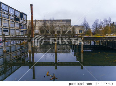Tranquil water feature displaying factory backdrop with perfect symmetry and quiet ripples Tranquil water feature displaying factory backdrop with perfect symmetry and quiet ripples 140046203