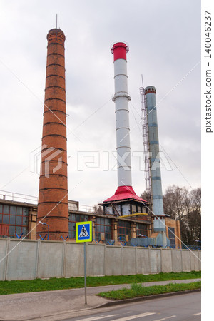 Cityscape illustrating industrial history through aged brick and current steel constructions against plain sky Cityscape illustrating industrial history through aged brick and current steel constructions against plain sky 140046237