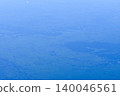 Looking through the airplane window with the view of cityscape under the clouds. Clouds above the city. Looking from aerial view. Nature and travel concept. 140046561